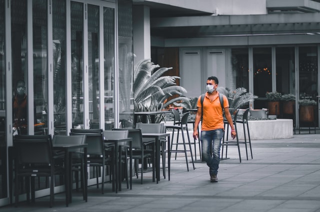 tourists wearing mask on an empty street during covid 19 pandemic lockdown in singapore